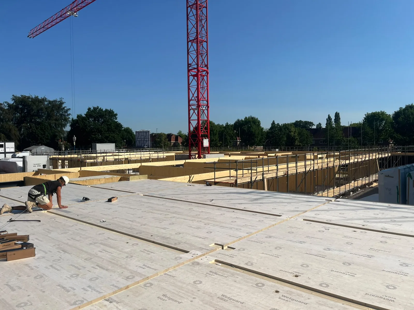 Overzicht van bouwelementen en een kraan op de projectlocatie